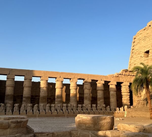 Rows of stone sphinxes beneath ancient columns at Karnak Temple in Luxor