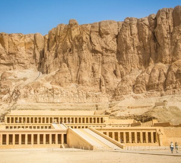 Visitors approaching the terraced Temple of Hatshepsut below the limestone cliffs of Deir el-Bahari