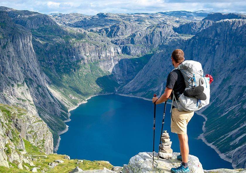 Backpacker overlooking a blue mountain lake