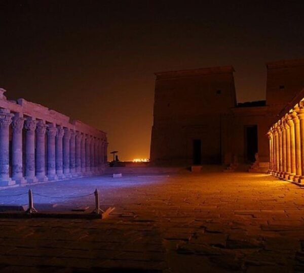 Blue and golden lighting along the colonnades of Philae Temple’s courtyard at night