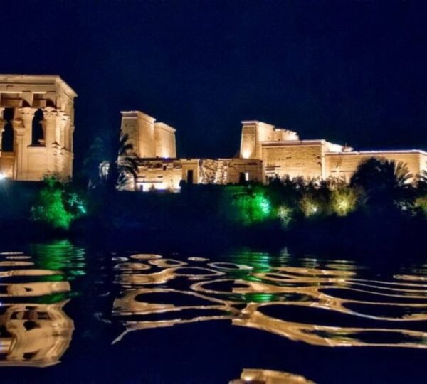 Philae Temple and Trajan’s Kiosk illuminated at night, with reflections shimmering on the Nile