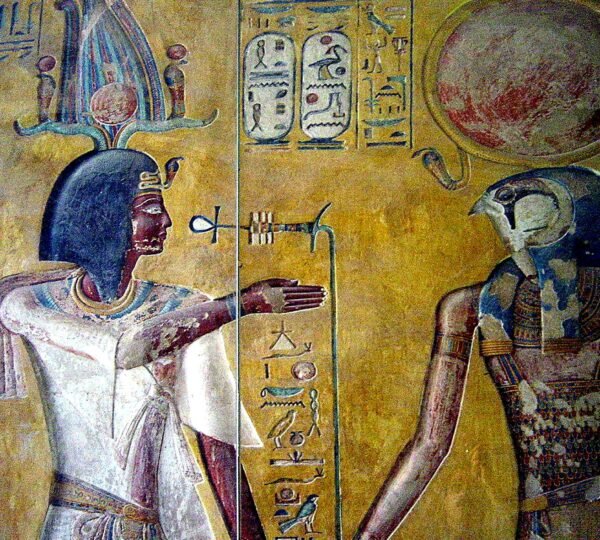 A richly colored tomb painting of a pharaoh facing a falcon-headed figure beneath a red sun disk
