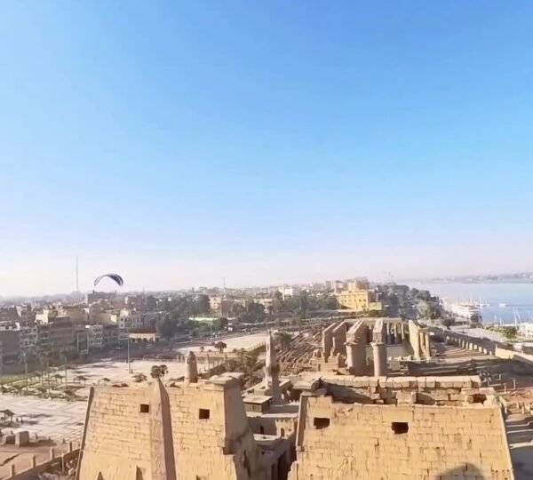 An aerial view of Luxor Temple’s entrance pylons, statues and courtyards beside the Nile