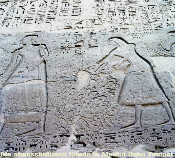 Carved Egyptian figures beside a pile of hands recorded in an ancient military victory scene at Medinet Habu