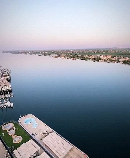 An aerial view of the Nile and moored cruise boats, including a boat with a pool on its upper deck