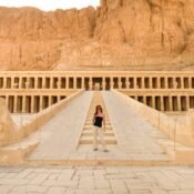 A traveler standing on the central ramp before the terraced colonnades of the Temple of Hatshepsut