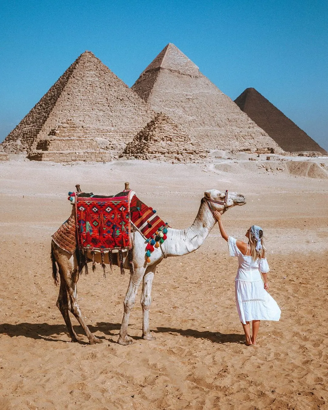 The pyramids of Giza rising above the desert under a clear blue sky