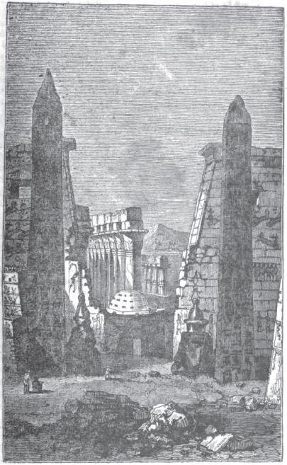 A monochrome historic illustration of two obelisks, columns and masonry at Luxor Temple