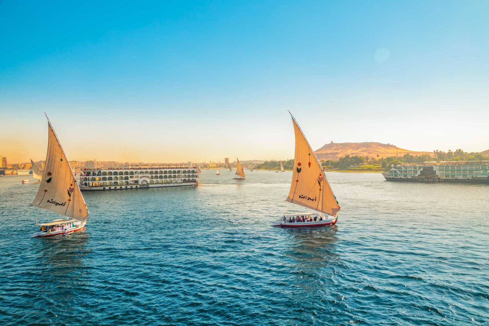 Traditional felucca sailboats on the Nile in Aswan at sunset